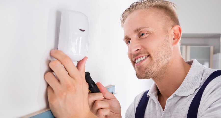 Man connecting a motion detector inside a home