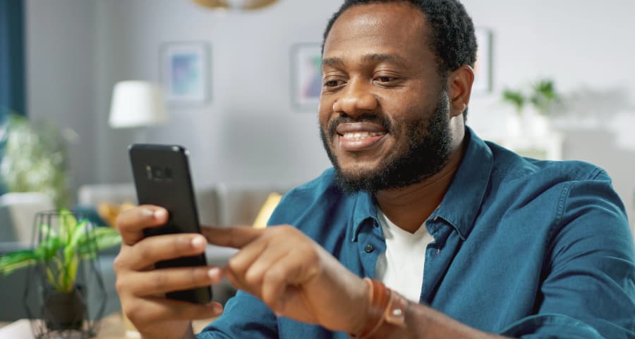 Man in his home using an app on his phone